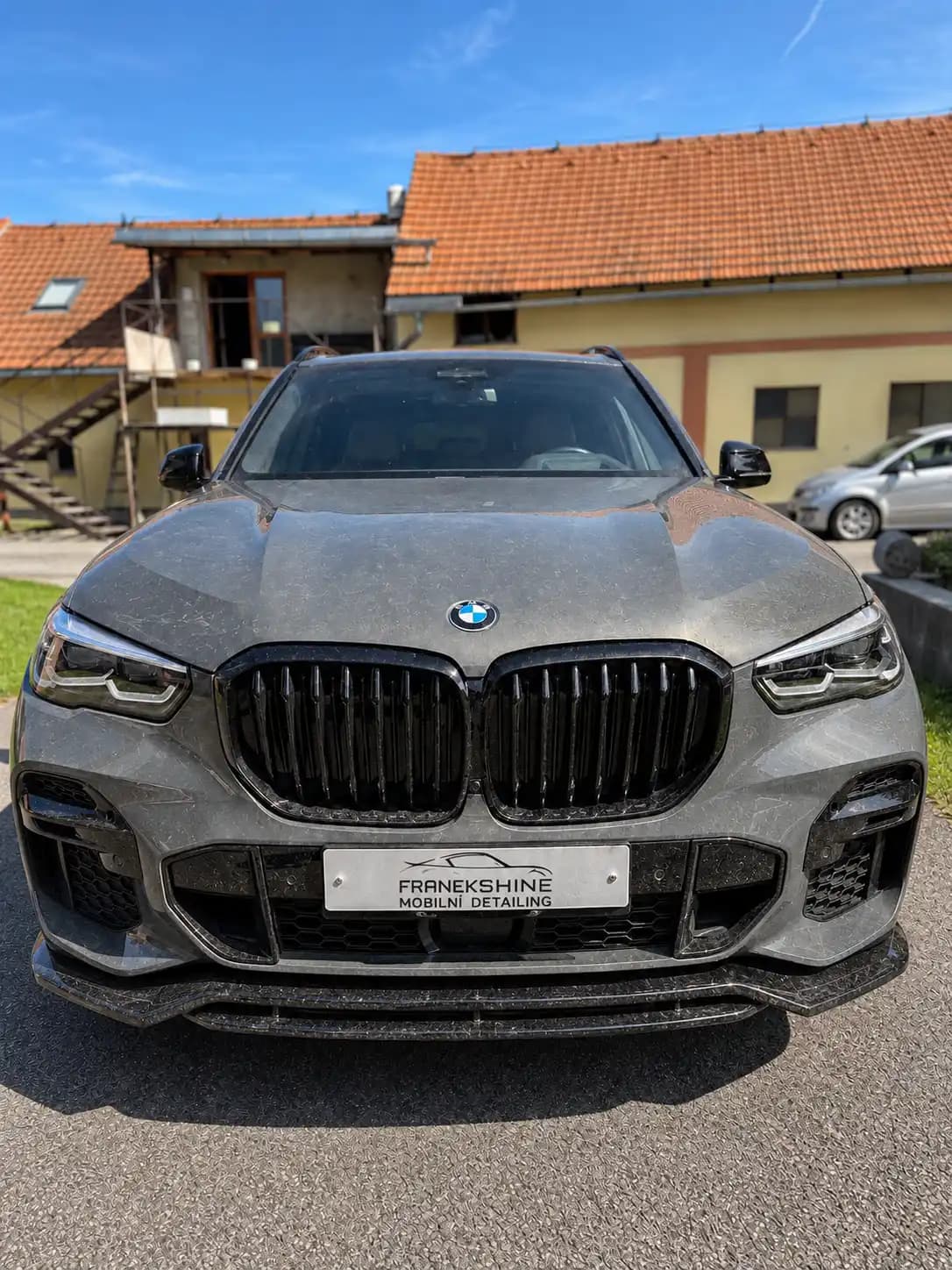 Šedé BMW X5 pokryté vrstvou prachu z polní cesty
